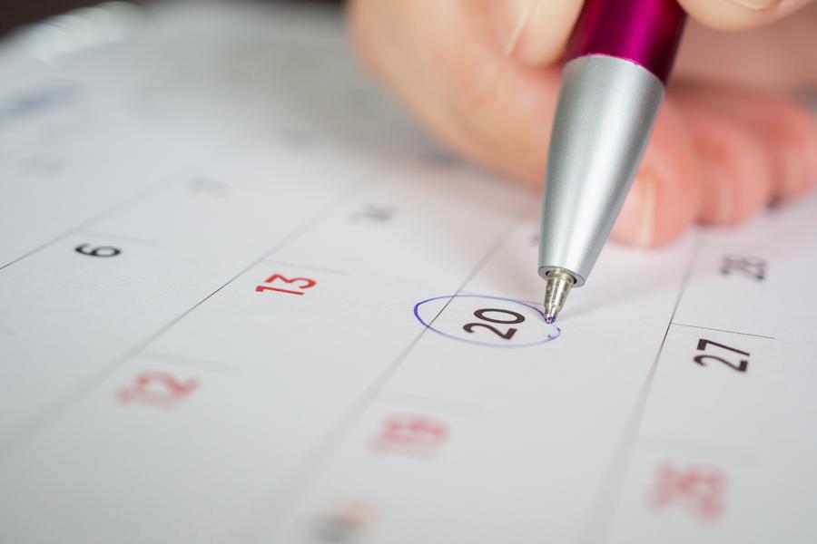Datum auf einem Kalenderblatt wird mit einem Kugelschreiber eingekreist