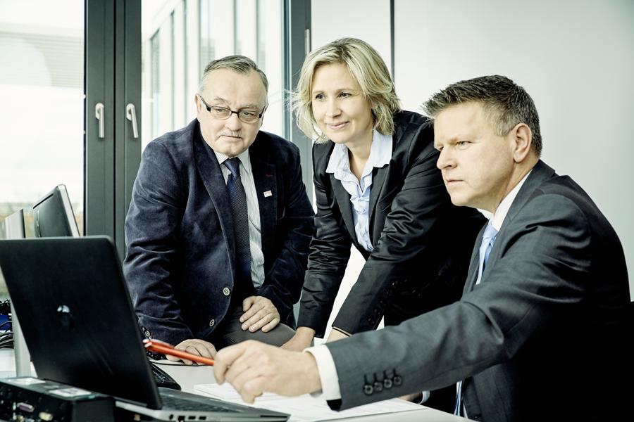 Three people in a consultation meeting looking at a computer